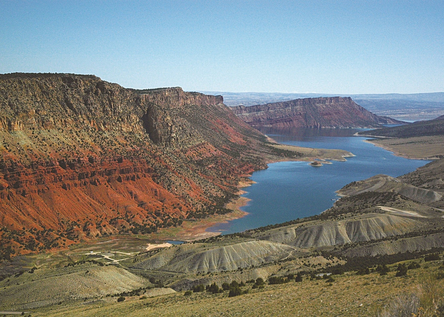 The red Triassic Moenkopi and Chinle Formations, visible north of Utah 44, were laid down by rivers and streams and in tidal flats. They contain tracks and fossils of amphibians and dinosaurs. Above them the yellow Nugget Sandstone forms a resistant cliff.