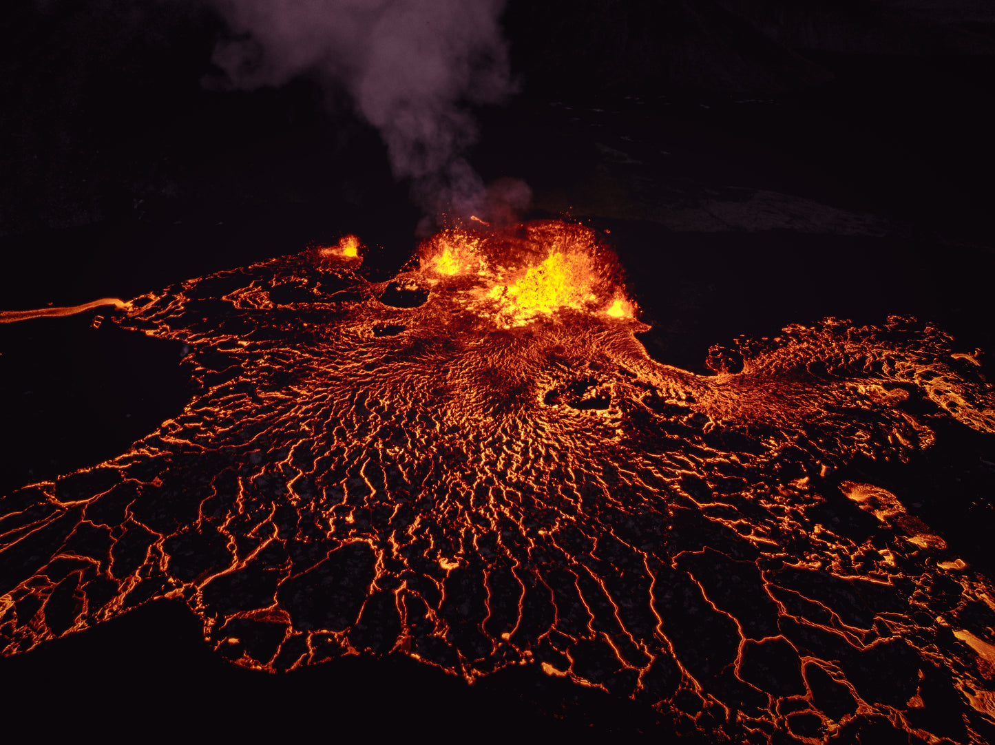 Lava flow with glowing orange and yellow colors against a dark background. Intro to Thermochronology image.