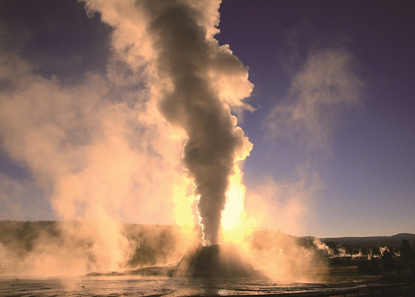 Castle Geyser erupting with steam and water at sunrise