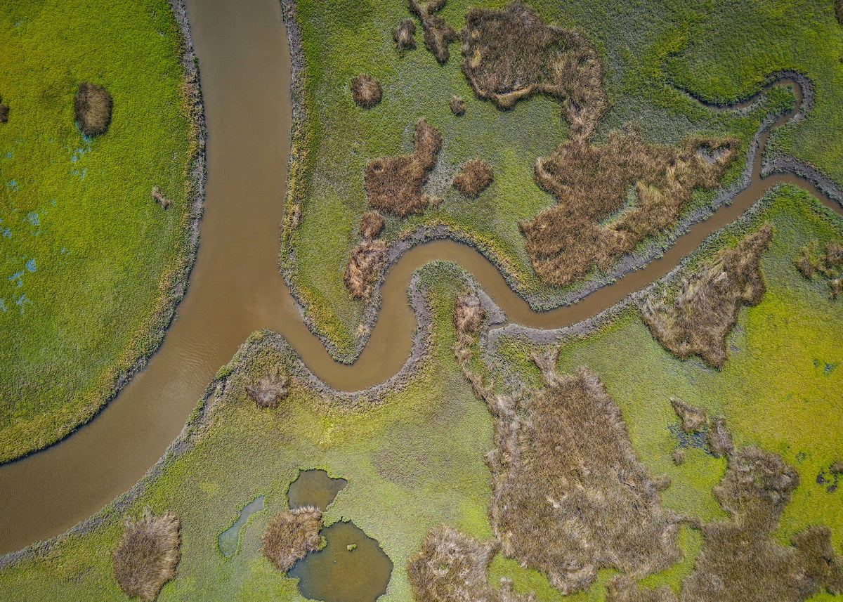 arial view of a river cutting through grassy land
