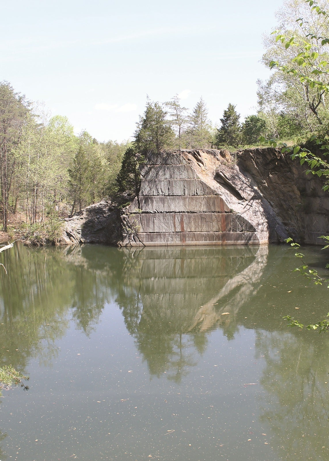 Man-made rock formation reflected in a pond surrounded by trees, Virginia