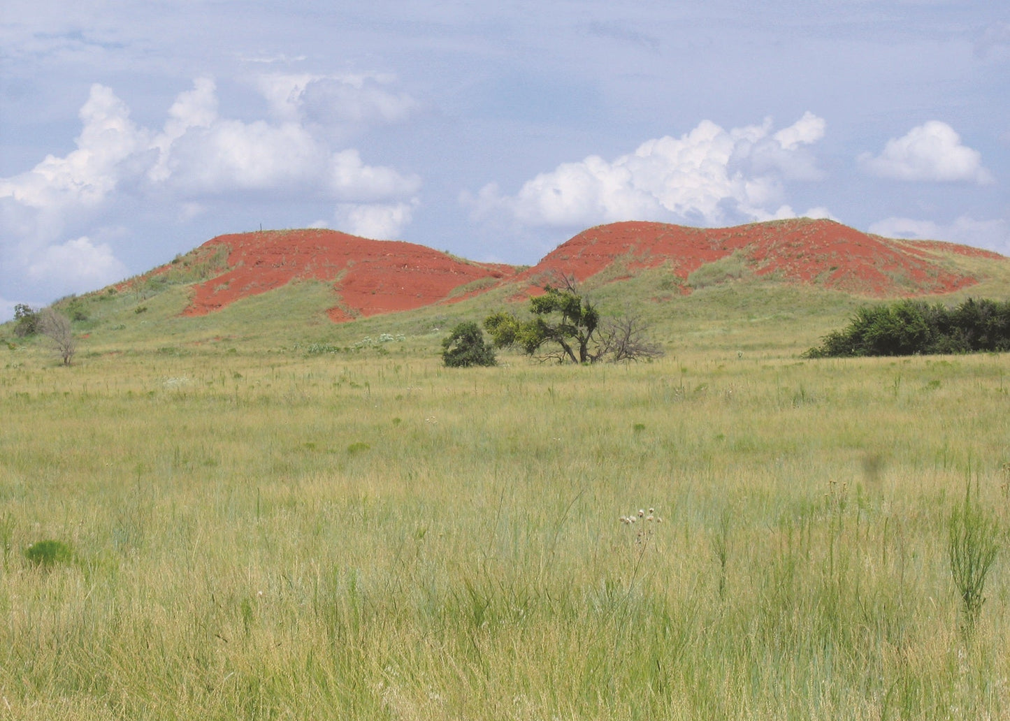 Doxey Hills, Oklahoma with red and green grass-covered hills. 