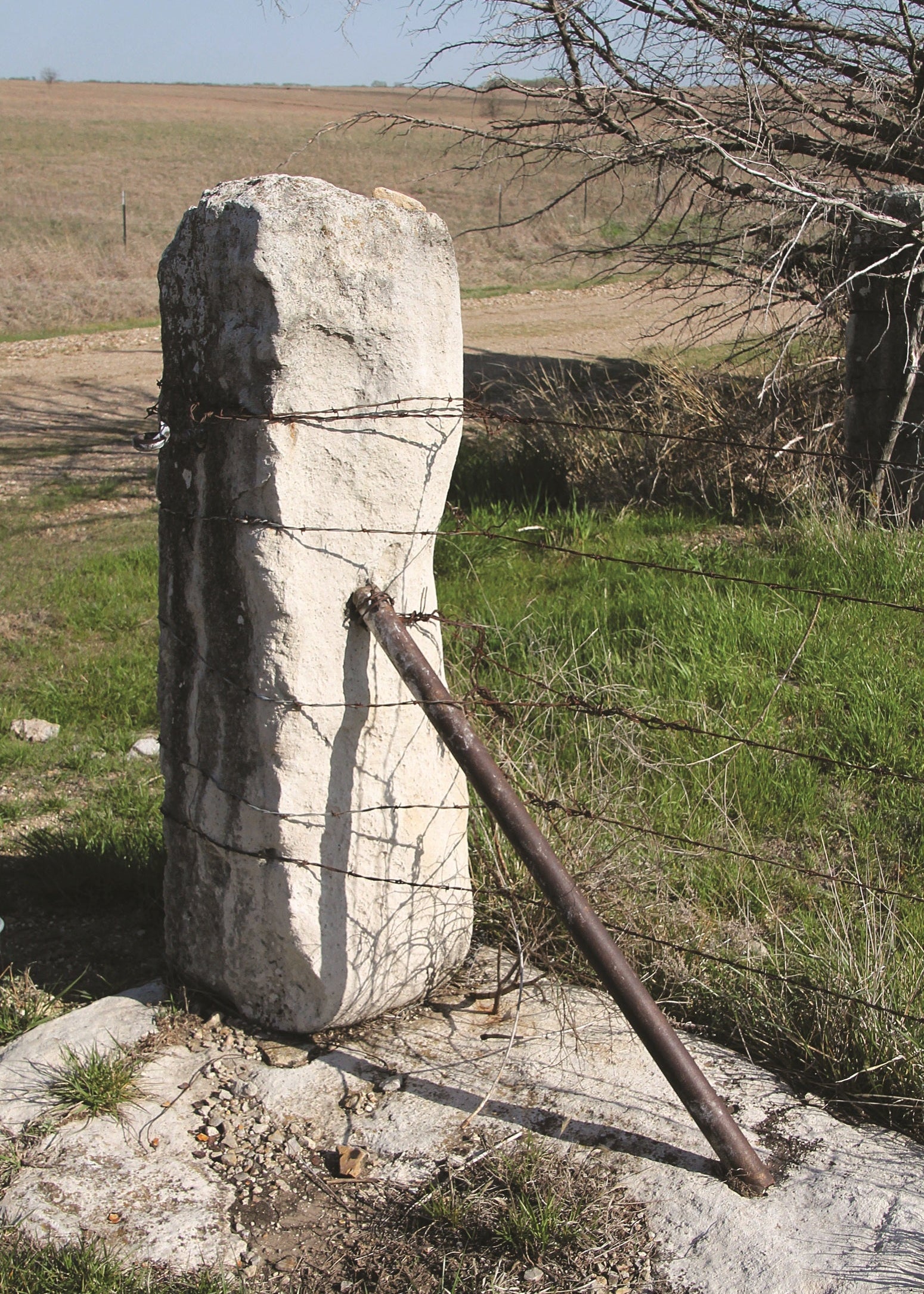 Stone marker with a metal rod in a field, Kansas