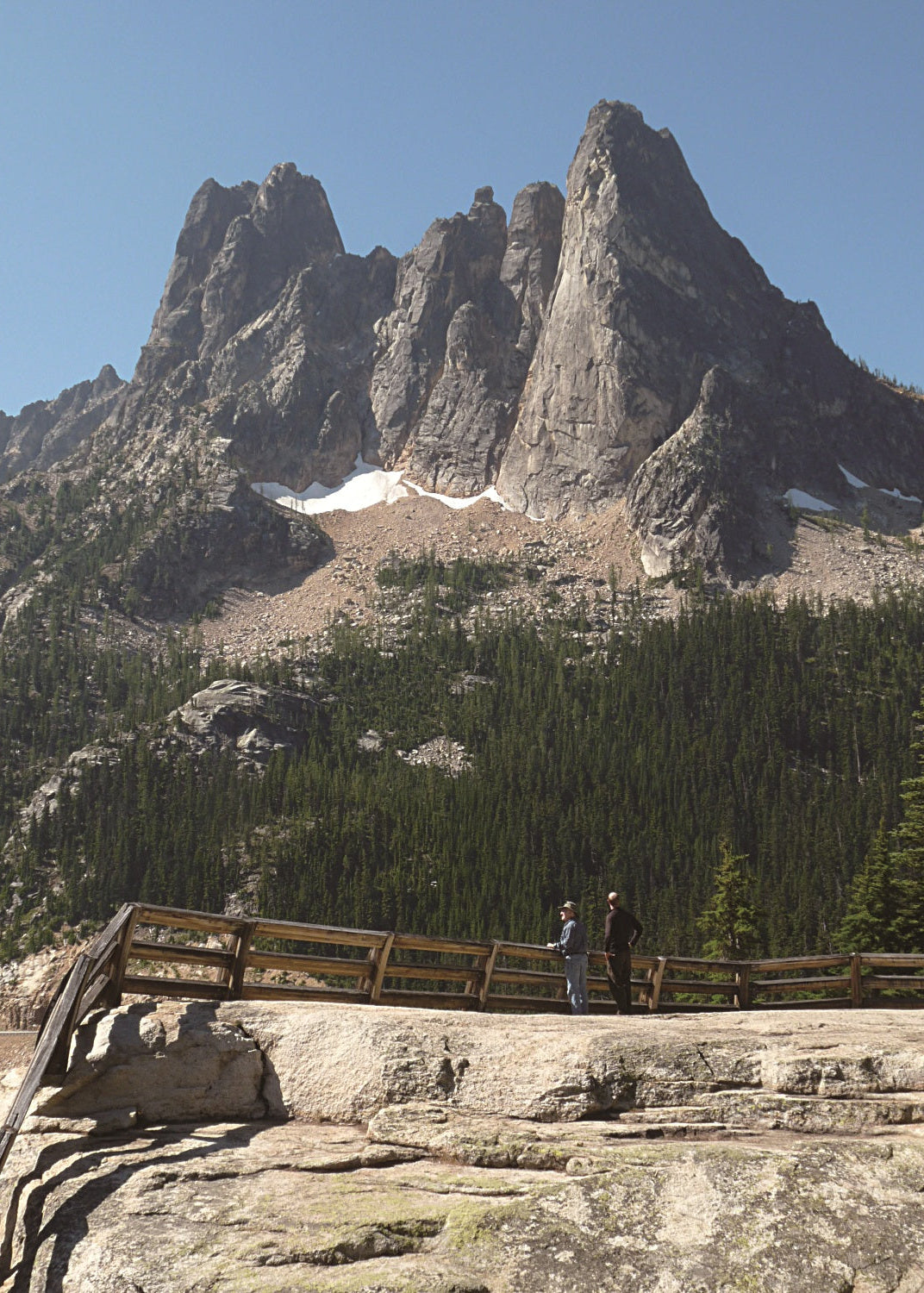 Scenic view of Liberty Bell Mountain with a wooden overlook and two people observing, Washington 