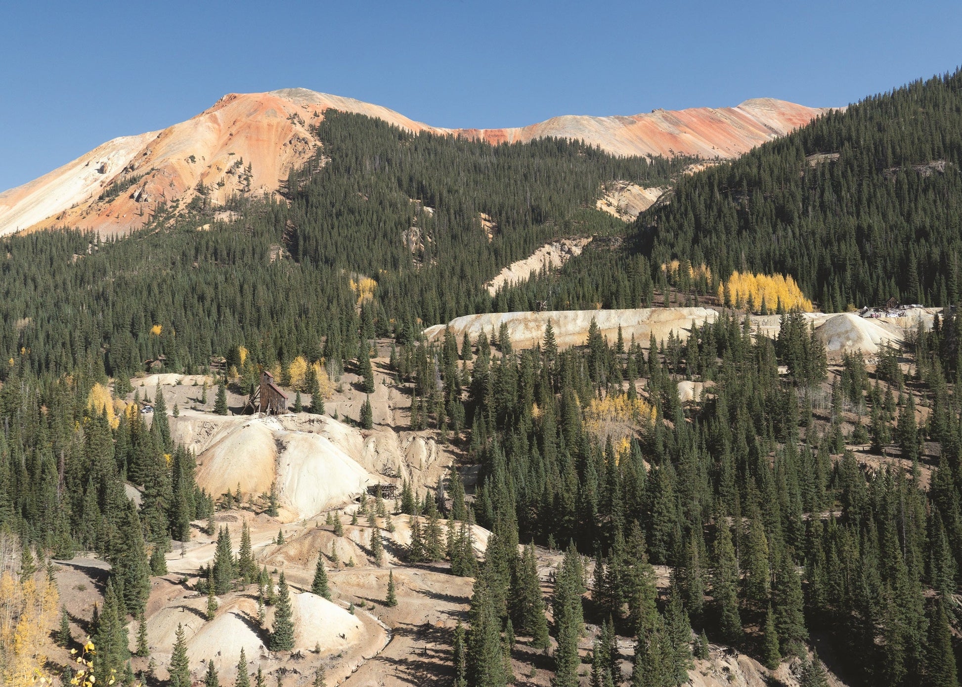 Mining area on Kendall Mountain, just south of Silverton, Colorado, showing chemically altered volcanic rocks against a blue sky. 