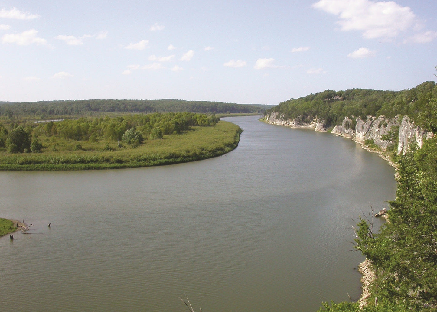 River with greenery on both sides under a blue sky with clouds, Missouri