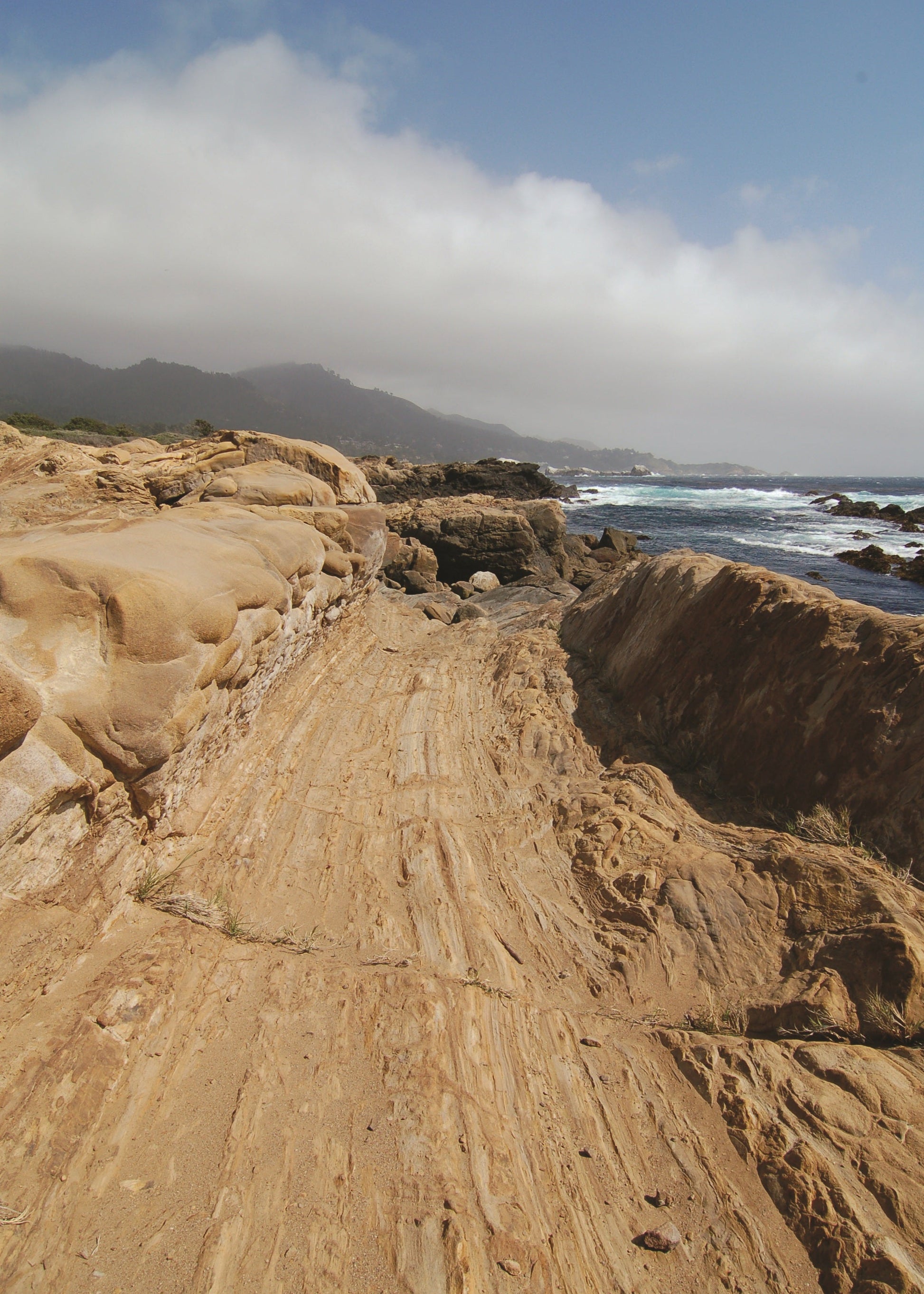 Rugged coastal landscape with rocky terrain and ocean waves.