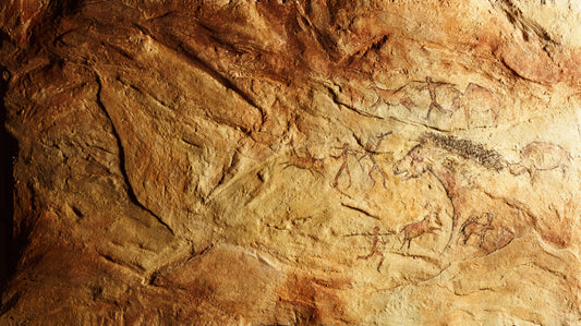 Ancient Rock Art image. Drawn images on a reddish-tan slab of rock.