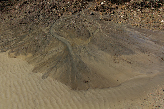 Alluvial fan stratigraphy image. Water flows over tannish-brown sand and rock.