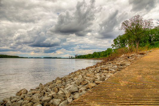 Path along a rocky shoreline with trees and a cloudy sky. Mississippi Embayment image.