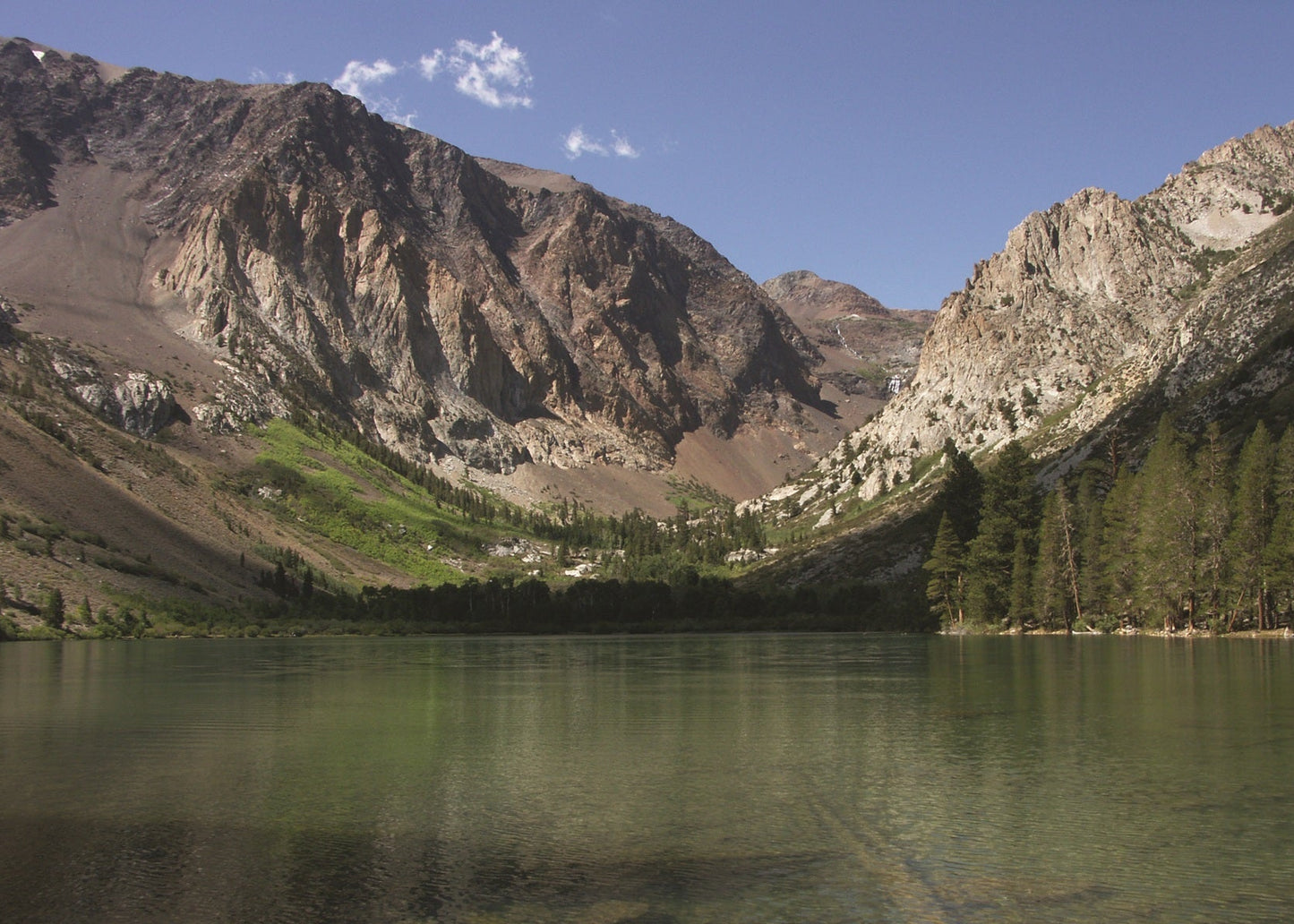 Mountain lake with reflective water surface and rocky mountains in the background, Yosemite 