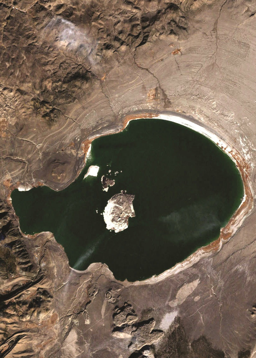Satellite view of a large crater lake surrounded by rugged terrain