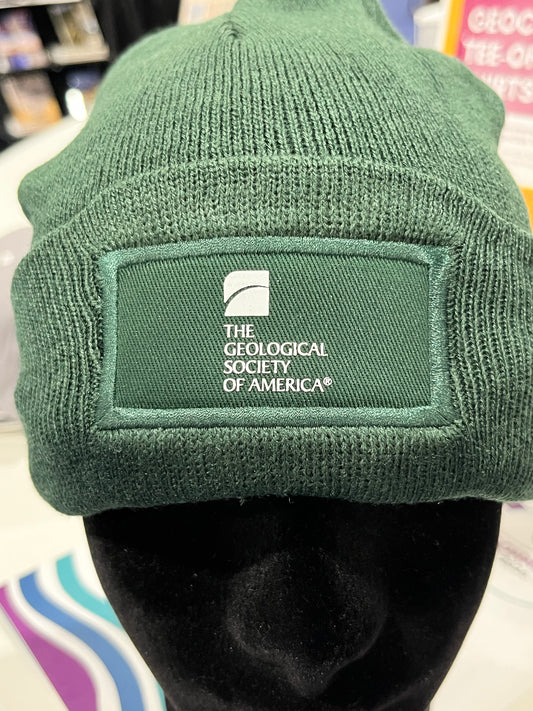 green beanie-style hat with a geological society of america logo 