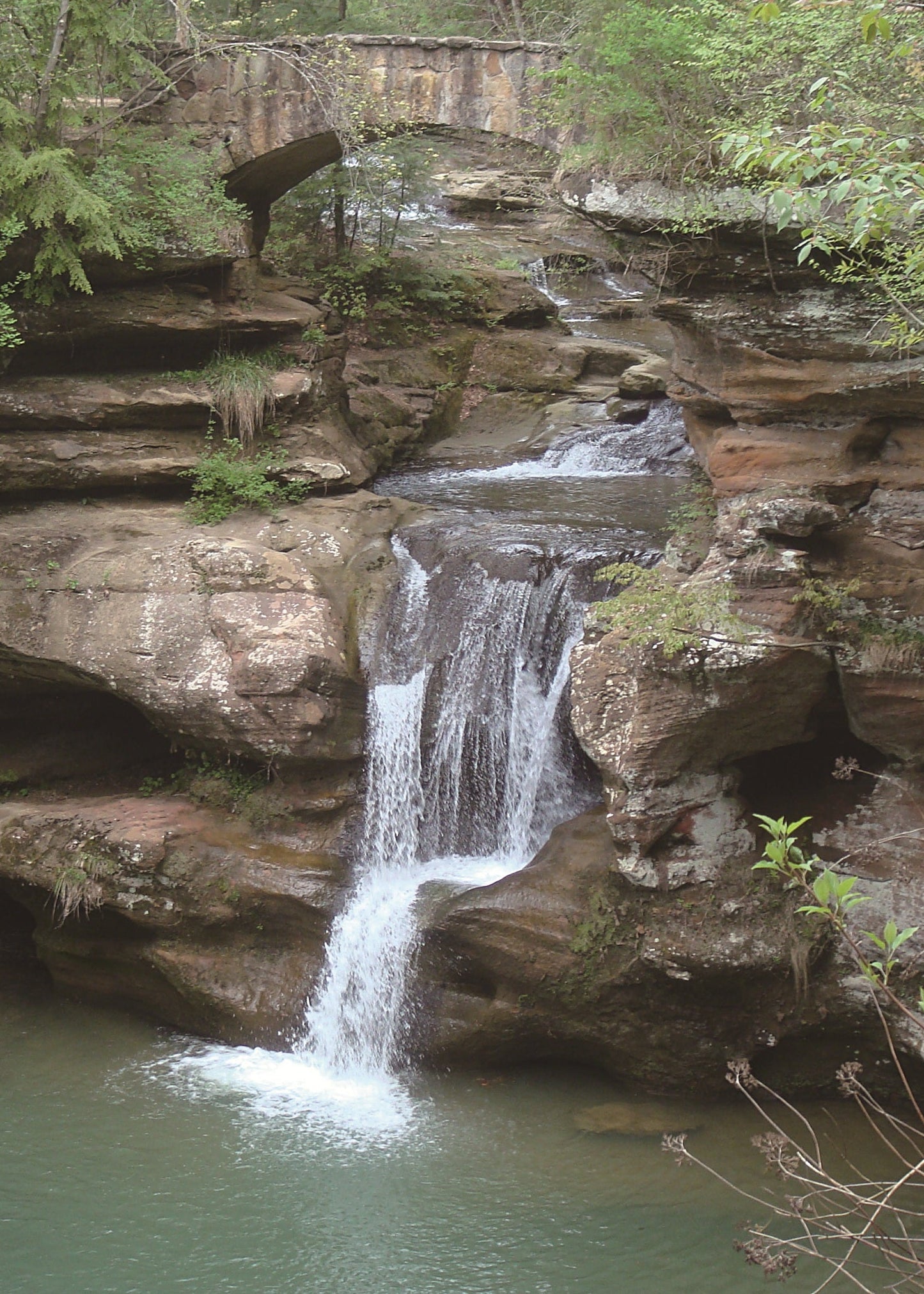 waterfall with a stone bridge and green trees, ohio 