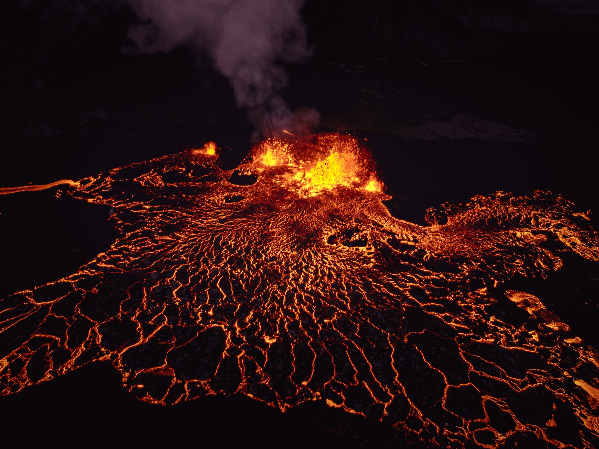 Lava flow with glowing orange and yellow colors against a dark background. Intro to Thermochronology image.