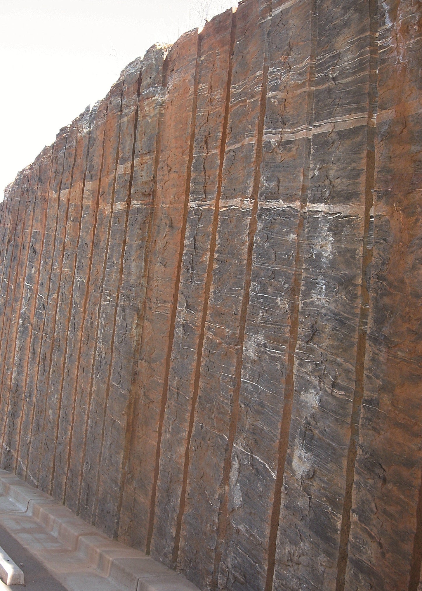 Rust-colored stone wall with vertical striations, Georgia