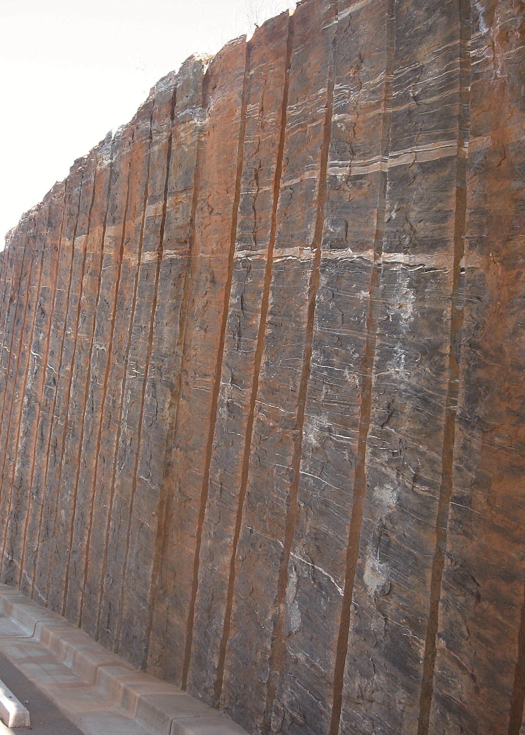 Rust-colored stone wall with vertical striations, Georgia